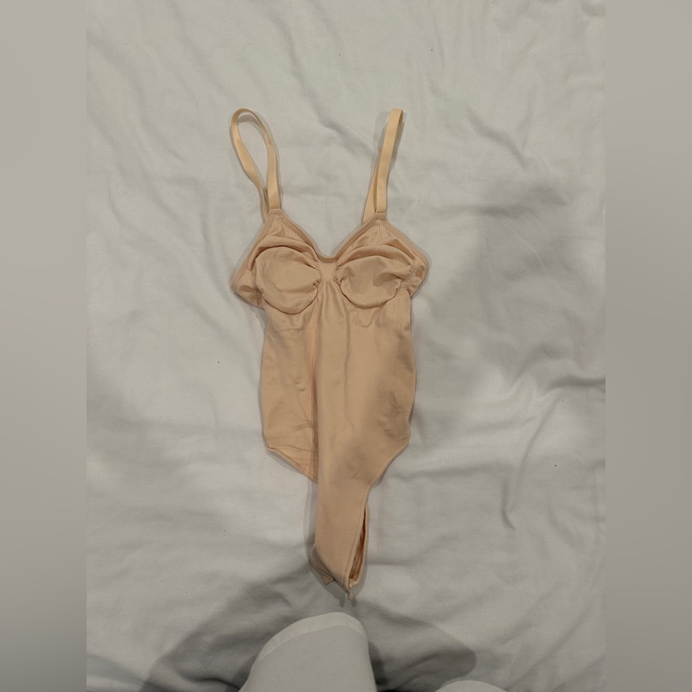 SKIMS: Sculpting thong bodysuit in sand
